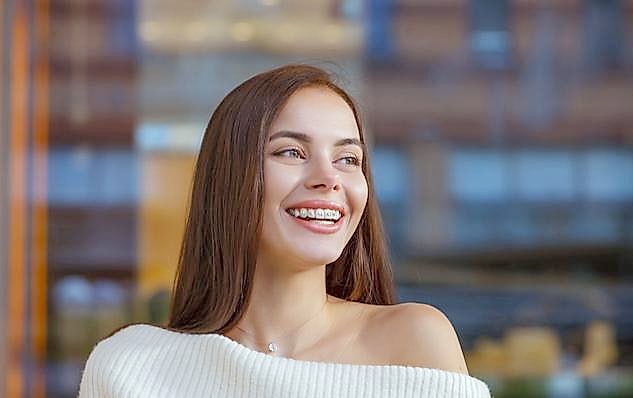 Teen with colorful metal braces smiling during an orthodontic visit
