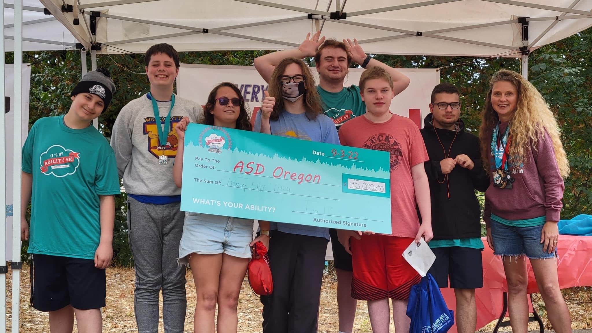 Group holding large check for ASD Oregon event
