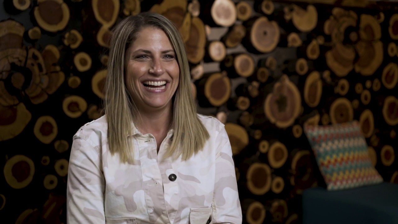 Woman smiling in room with wooden log background