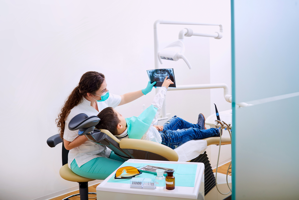 Dentist showing X-ray to child patient.