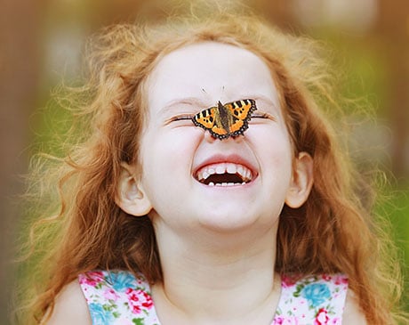 Laughing child with butterfly on nose