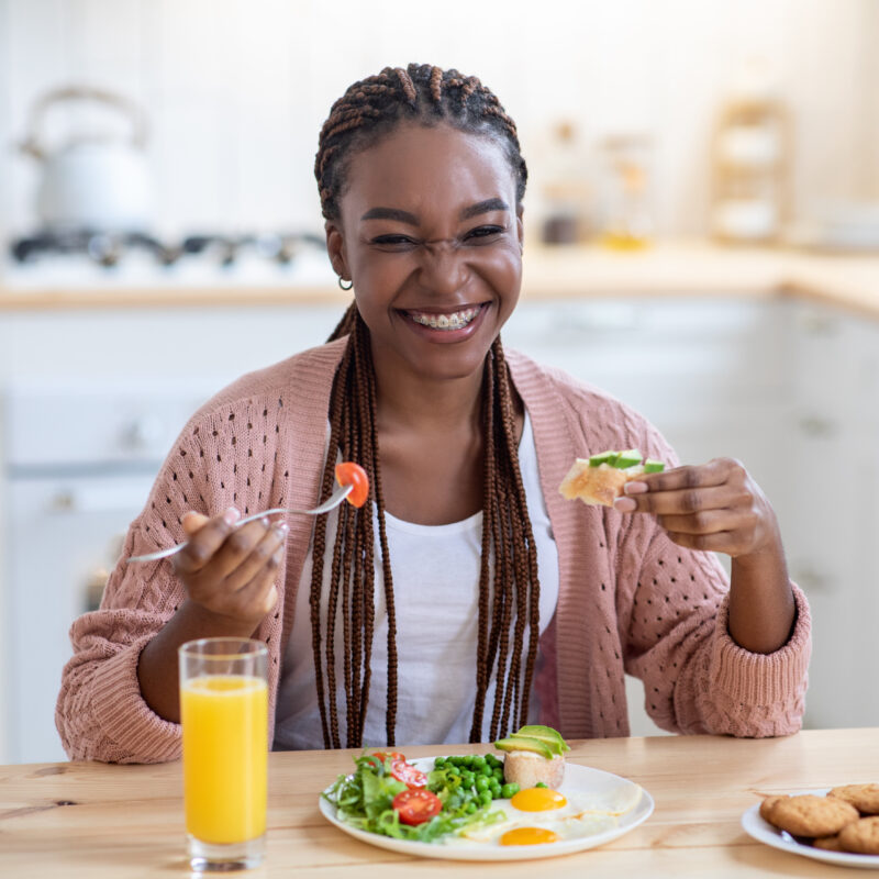 Smiling woman enjoying healthy breakfast in kitchen.