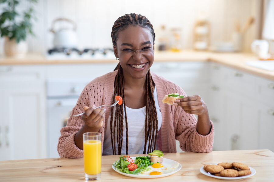 Smiling woman enjoying healthy breakfast in kitchen.