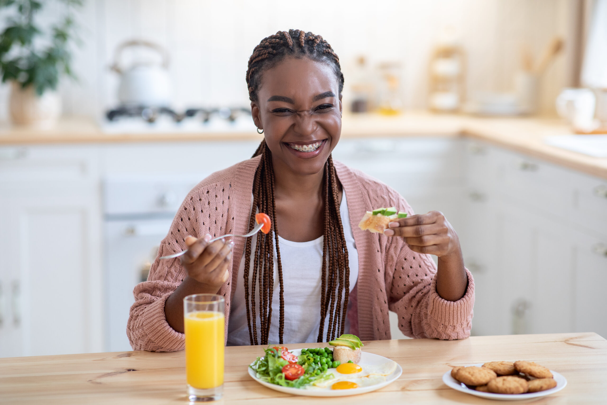 Smiling woman enjoying healthy breakfast in kitchen.