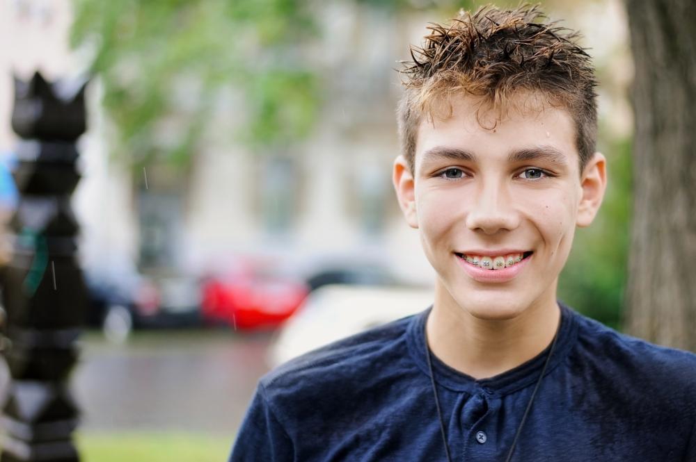 Smiling teen with braces outdoors