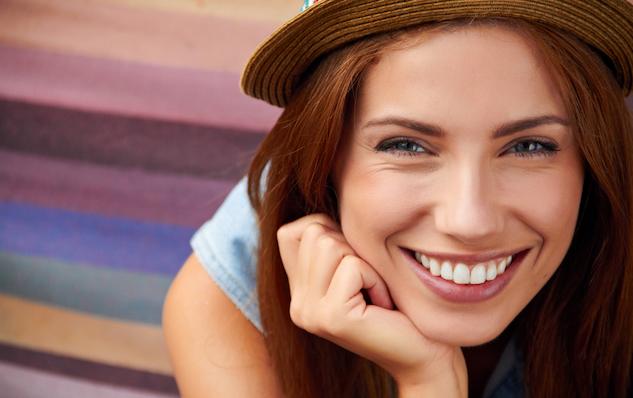 smiling women with white teeth and brown hat