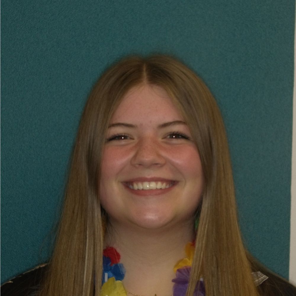 Young woman smiling against blue background