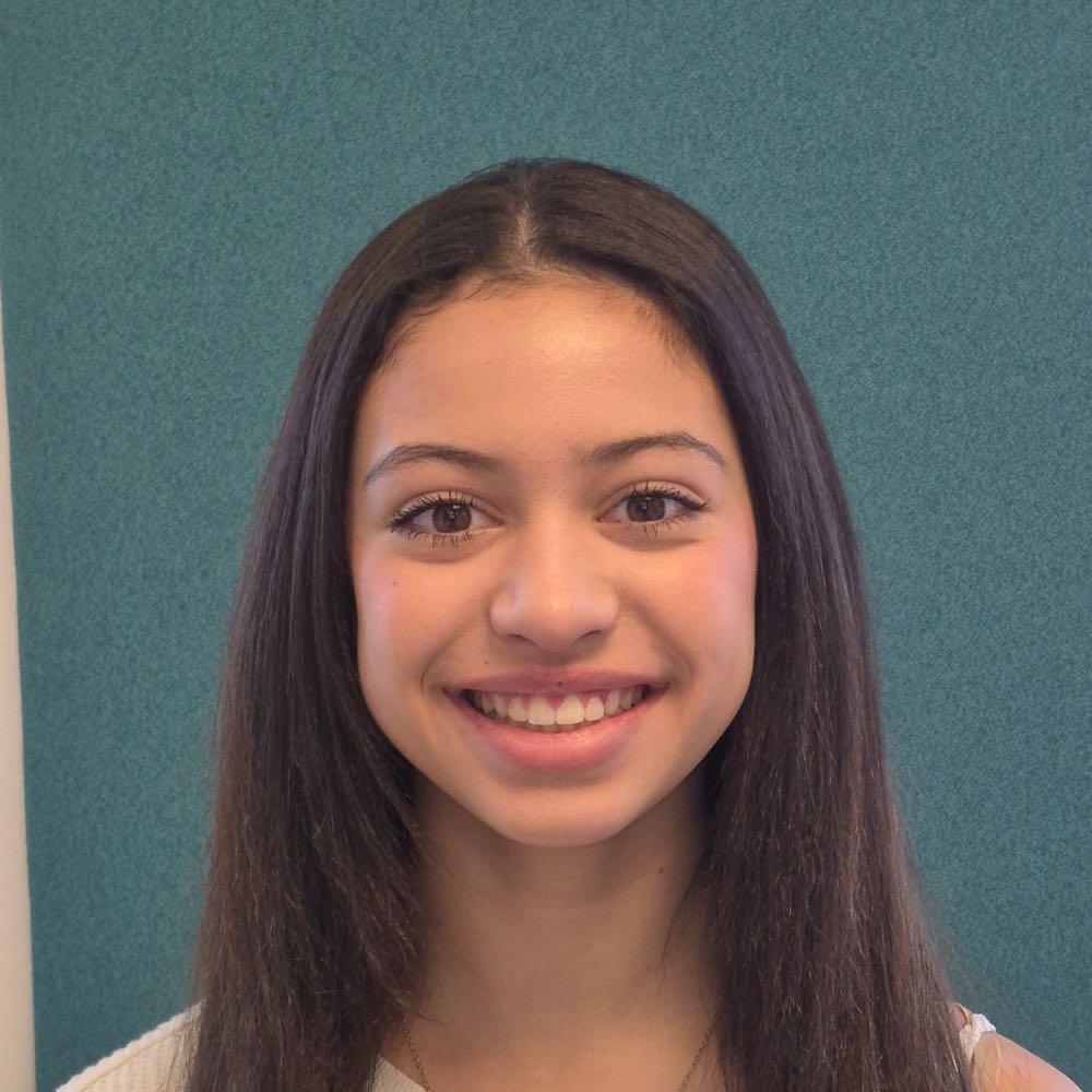 Young woman smiling against teal background