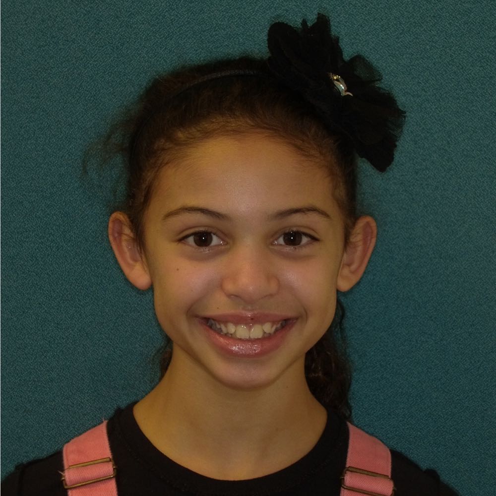 Young girl smiling with black hair accessory